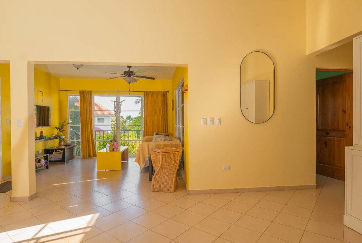 buyDRproperty Bright living room with yellow walls in a Hispaniola Two Unit Villa. Sosua Real Estate