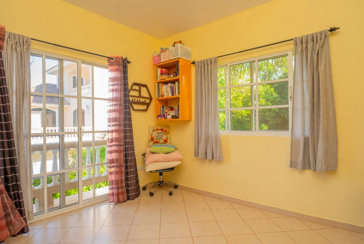 buyDRproperty Bright yellow room with a window, curtains, and a bookshelf in a residential Hispaniola Two Unit Villa. Sosua Real Estate