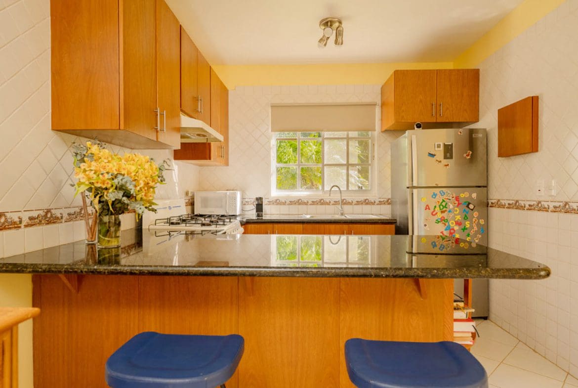 buyDRproperty Kitchen in a Hispaniola Two Unit Villa with breakfast bar and wooden cabinets. Sosua Real Estate