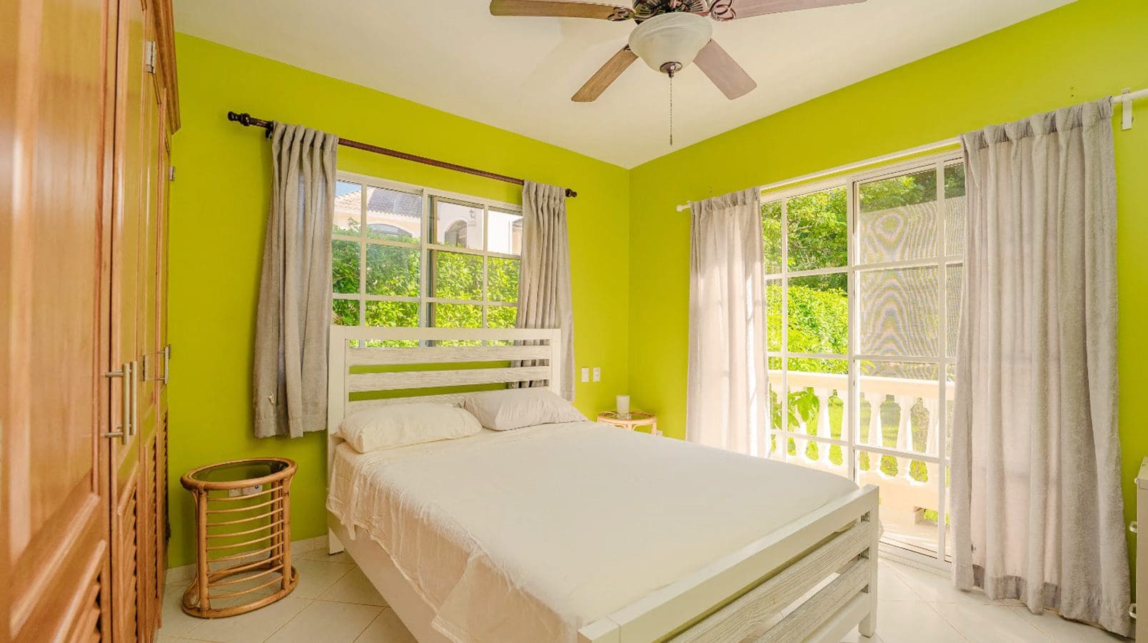 buyDRproperty Bedroom in Hispaniola Two Unit Villa with bright green walls and white bed. Sosua Real Estate