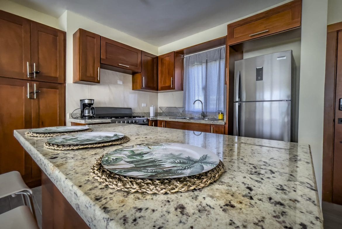 buyDRproperty Kitchen in a 2 Bedroom Villa For Sale, featuring granite countertops and wooden cabinets. Sosua Real Estate