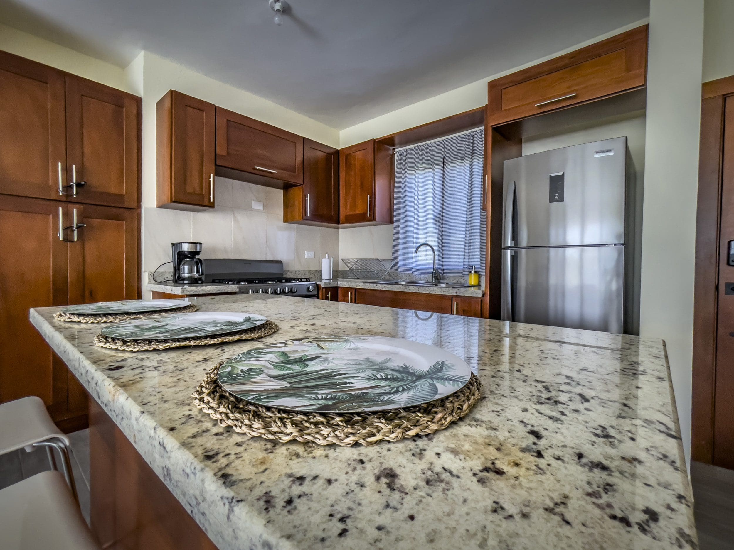 buyDRproperty Kitchen in a 2 Bedroom Villa For Sale, featuring granite countertops and wooden cabinets. Sosua Real Estate