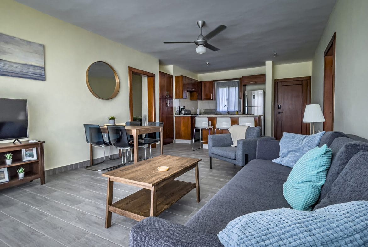 buyDRproperty Living room of a 2 bedroom villa for sale, featuring a sofa, dining area, and kitchen. Sosua Real Estate