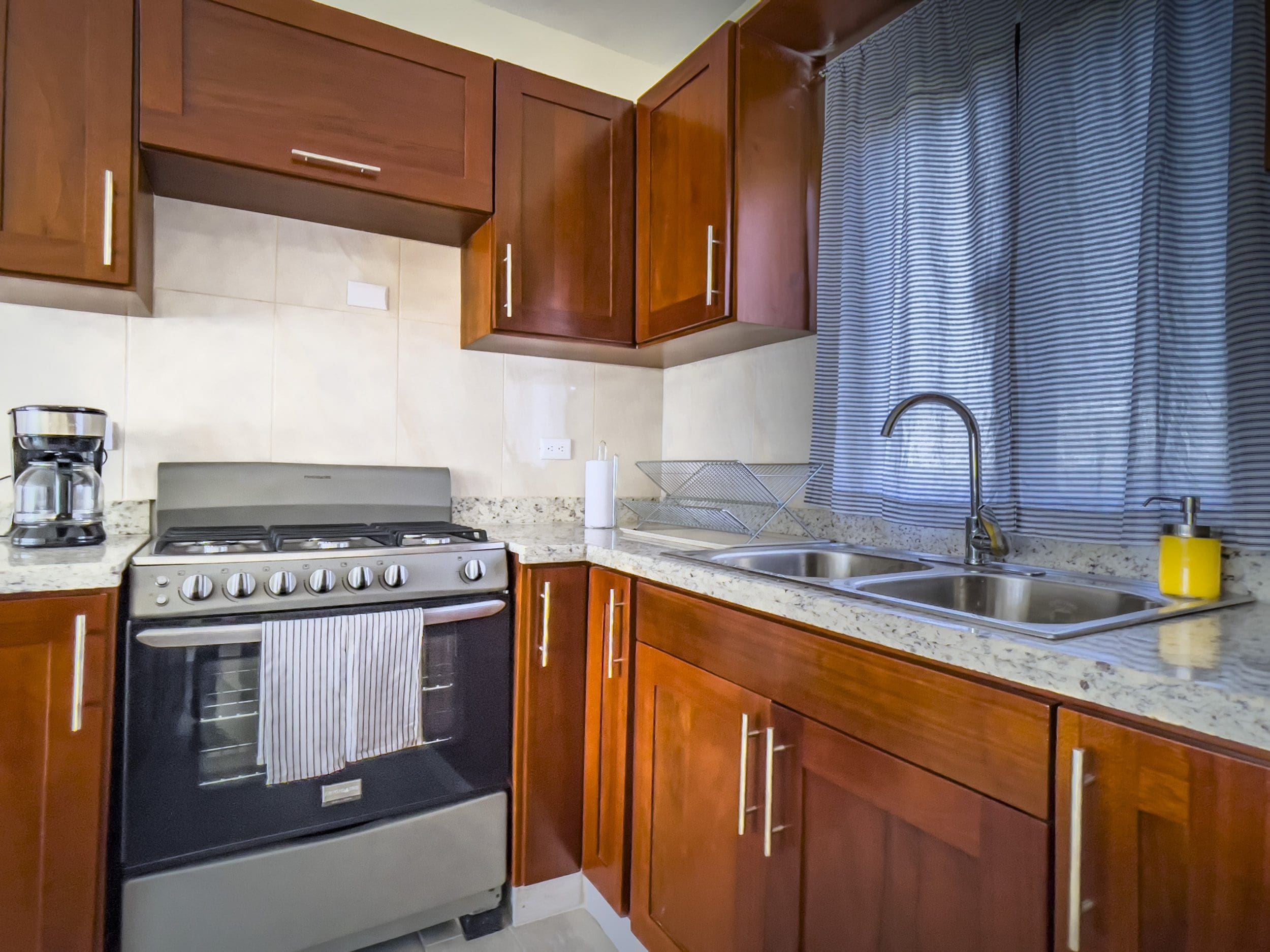 buyDRproperty Kitchen in a 2 Bedroom Villa For Sale, featuring wooden cabinets and a stove. Sosua Real Estate
