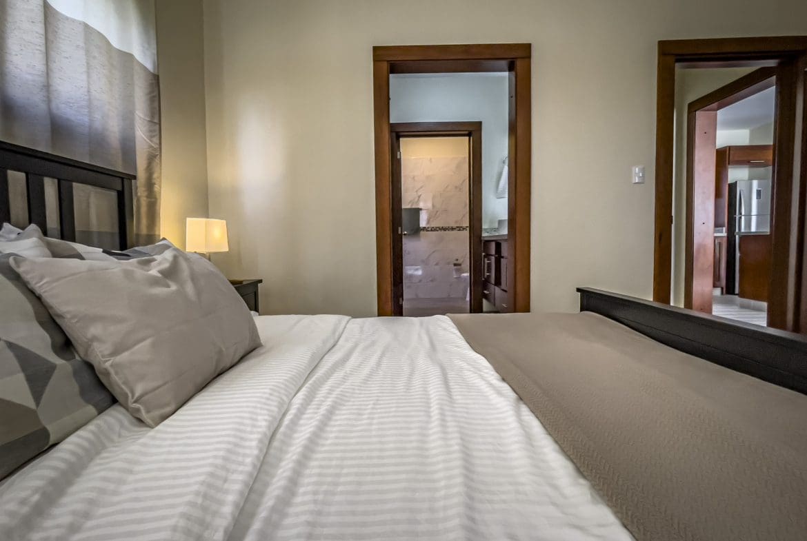 buyDRproperty Bedroom view of a 2 Bedroom Villa For Sale with open doors to bathroom and kitchen Sosua Real Estate
