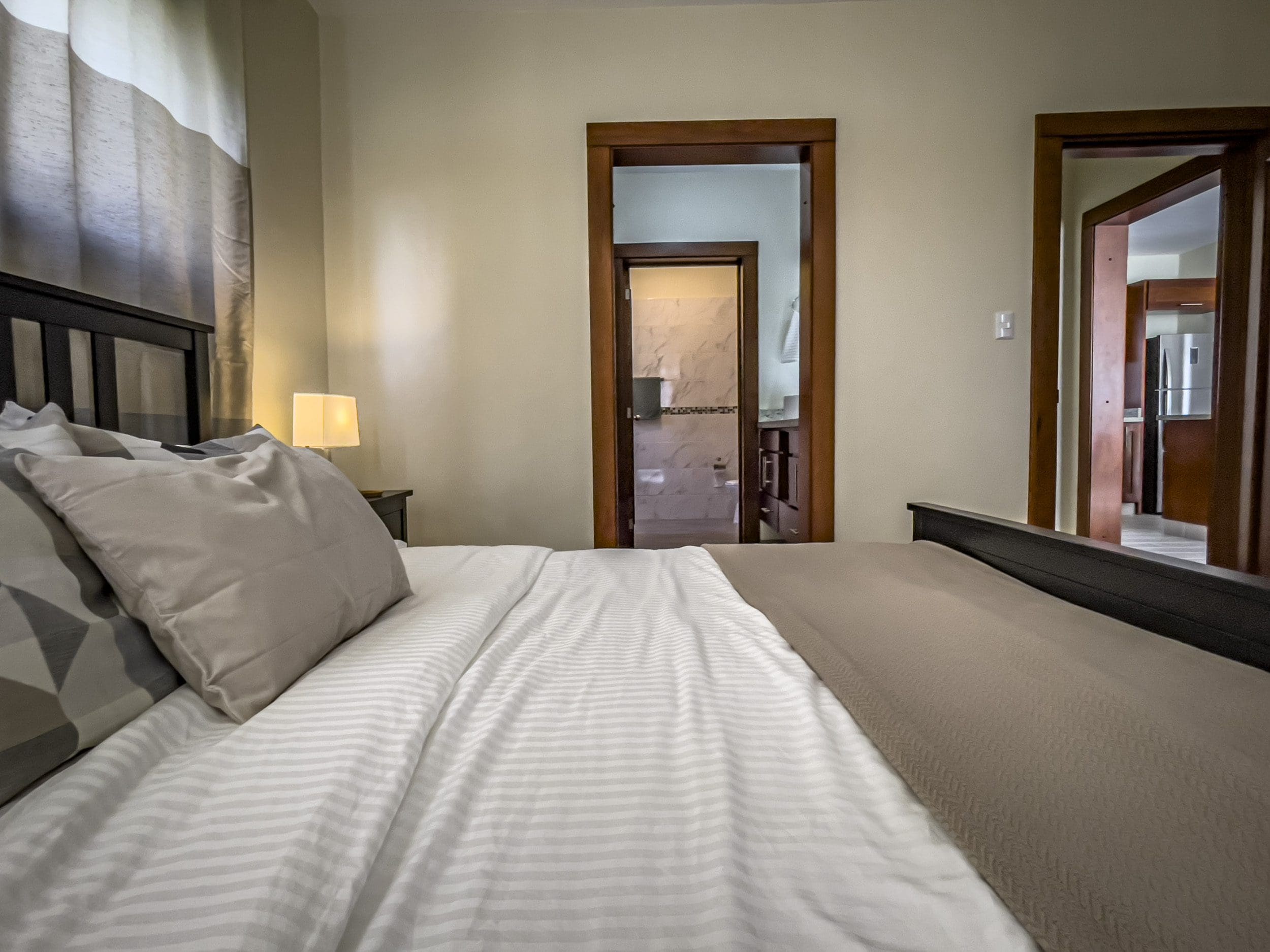 buyDRproperty Bedroom view of a 2 Bedroom Villa For Sale with open doors to bathroom and kitchen Sosua Real Estate