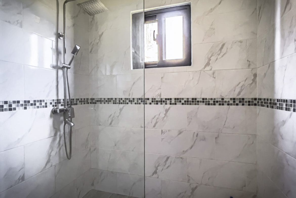 buyDRproperty Modern bathroom with marble tile, shower, and a window. 2 Bedroom Villa For Sale. Sosua Real Estate