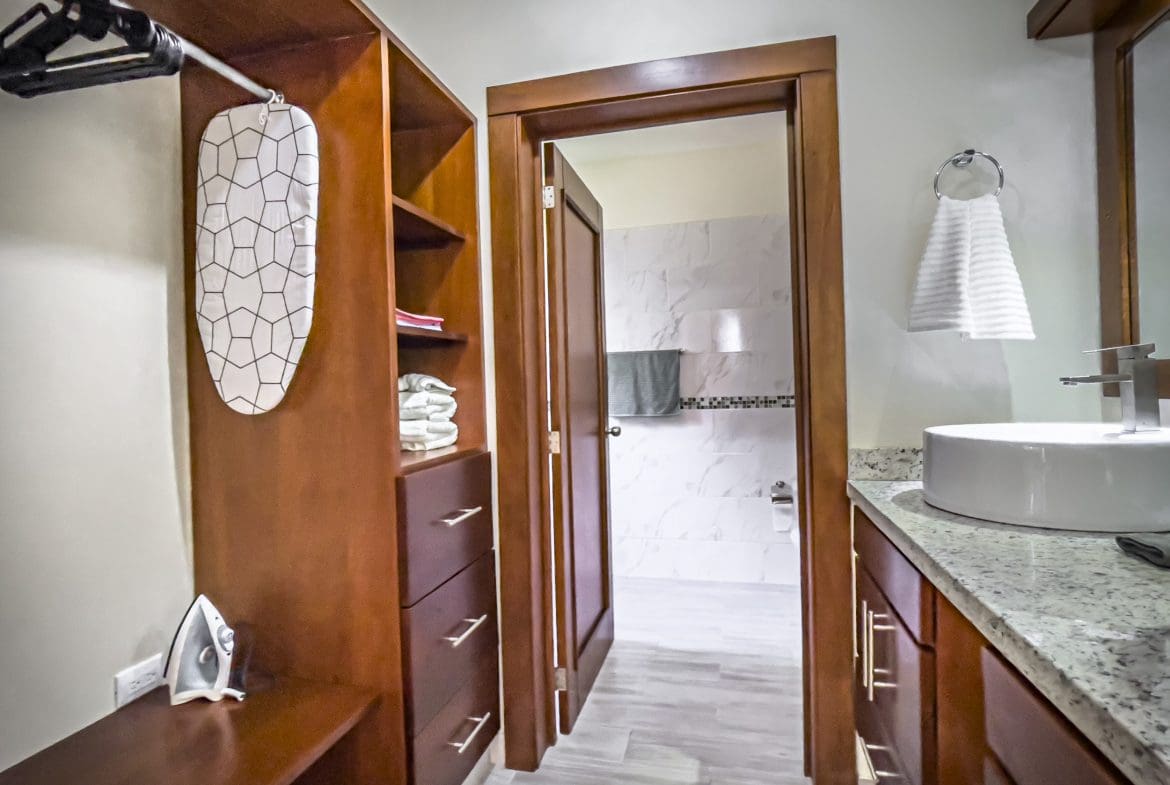 buyDRproperty Wooden closet with ironing board leading to a bathroom in a 2 bedroom villa for sale. Sosua Real Estate