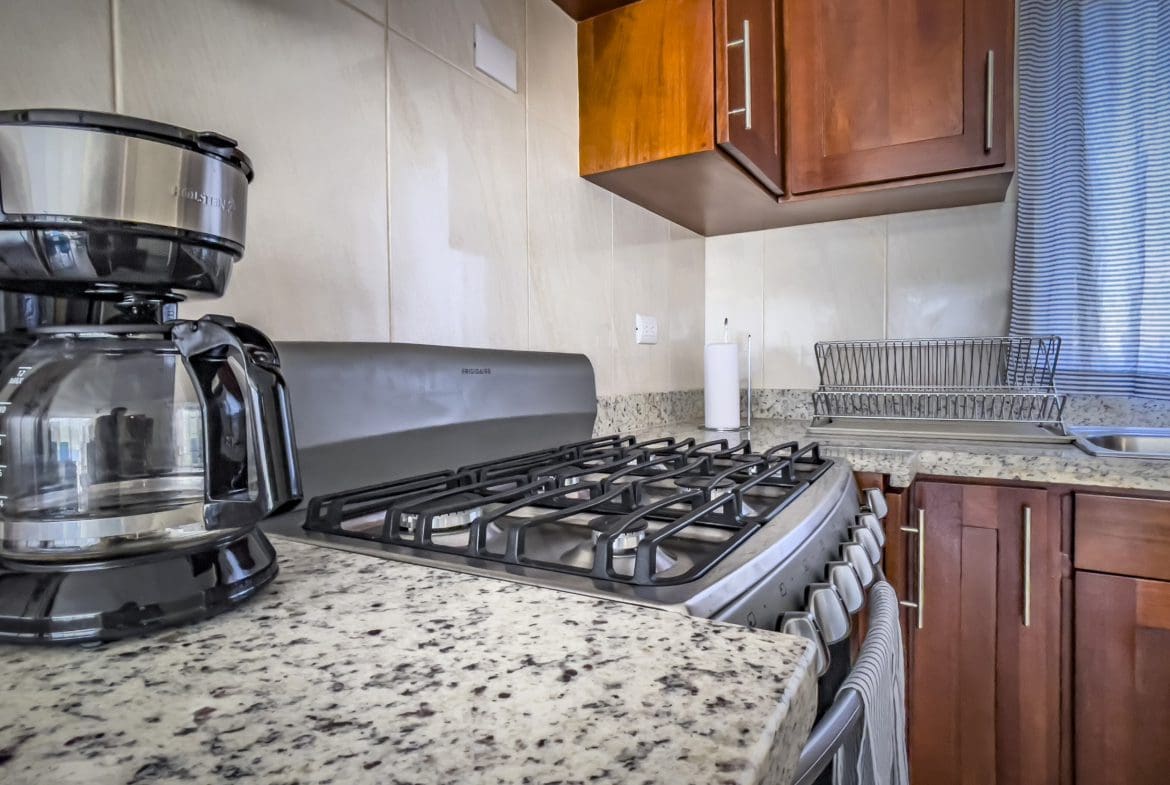 buyDRproperty Kitchen in a 2 Bedroom Villa For Sale. Features a stovetop, coffee maker, and granite countertop. Sosua Real Estate