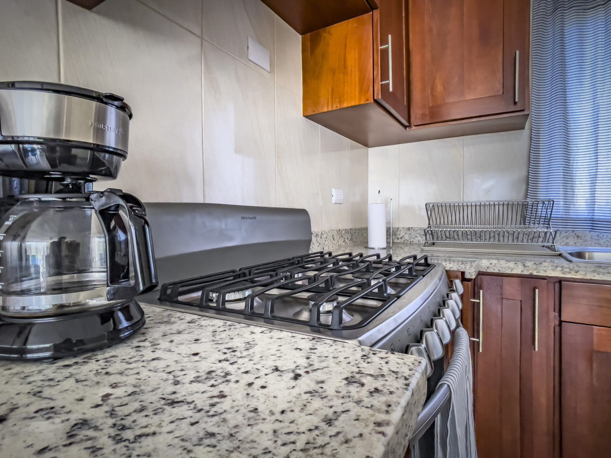 buyDRproperty Kitchen in a 2 Bedroom Villa For Sale. Features a stovetop, coffee maker, and granite countertop. Sosua Real Estate