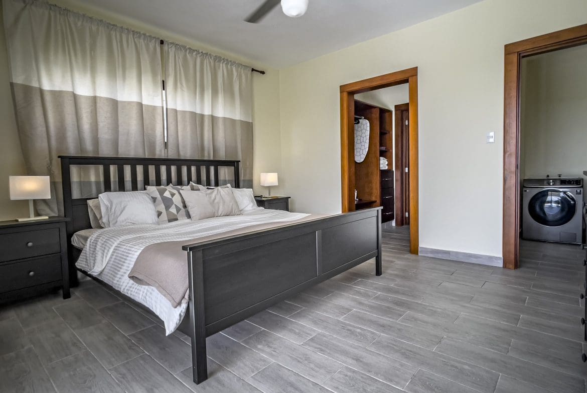buyDRproperty Bedroom of a 2 bedroom villa for sale, featuring a bed, curtains, and wood-look tile flooring. Sosua Real Estate