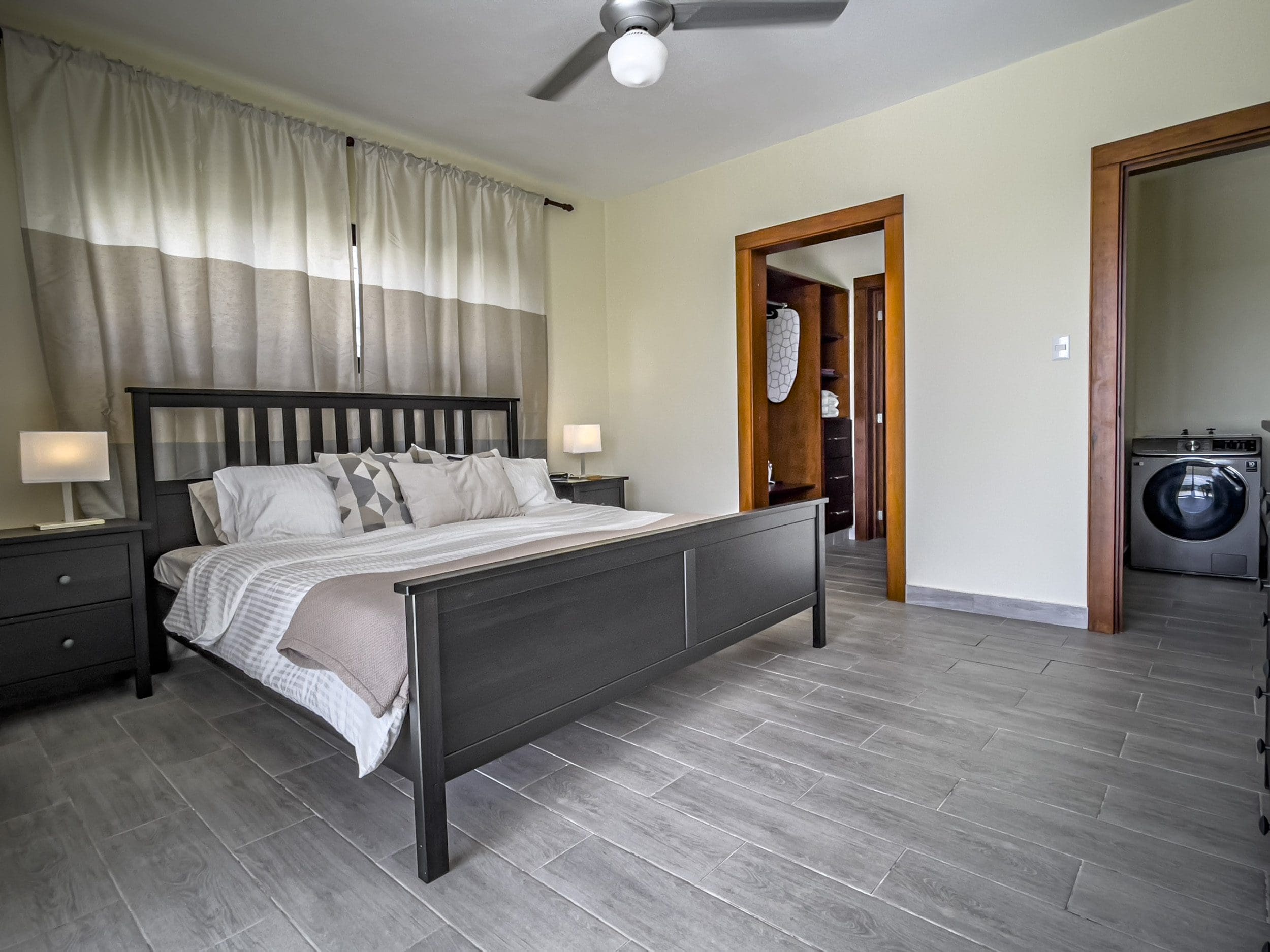 buyDRproperty Bedroom of a 2 bedroom villa for sale, featuring a bed, curtains, and wood-look tile flooring. Sosua Real Estate