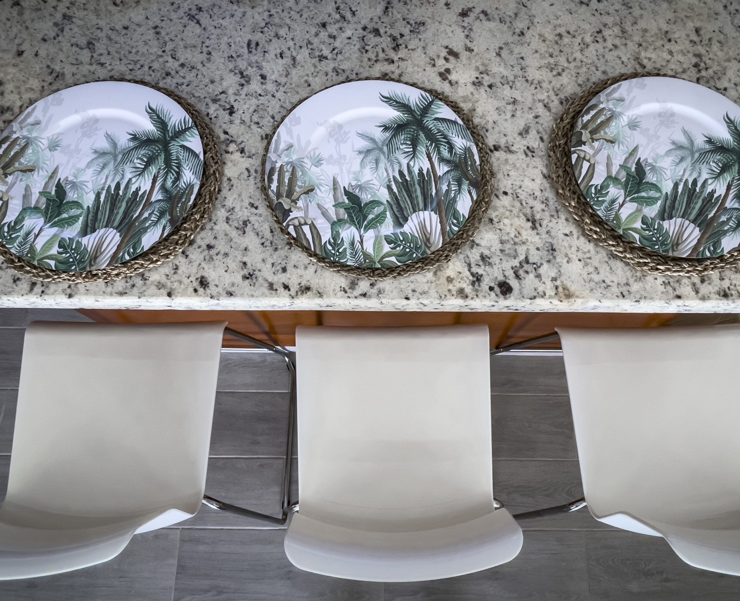 buyDRproperty Three place settings with tropical palm tree design on a granite countertop, perfect for a 2 Bedroom Villa For Sale. Sosua Real Estate