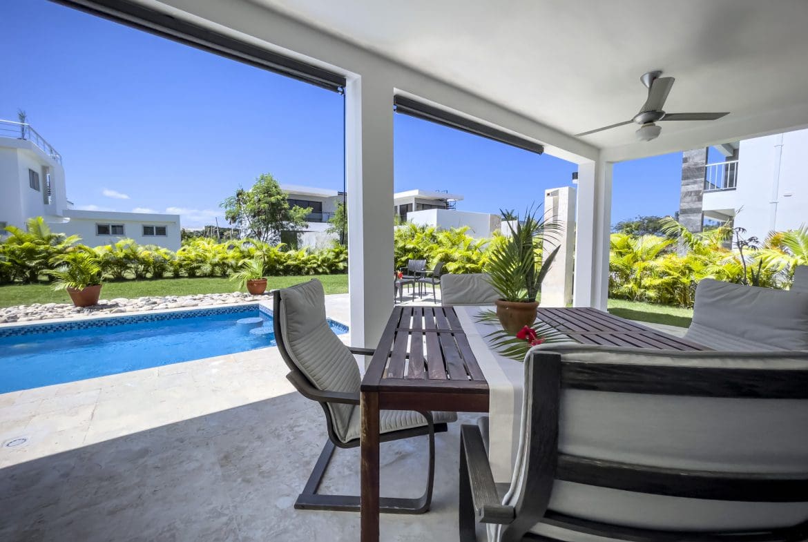 buyDRproperty Outdoor patio of a 2 bedroom villa for sale with a pool and dining table. Sosua Real Estate