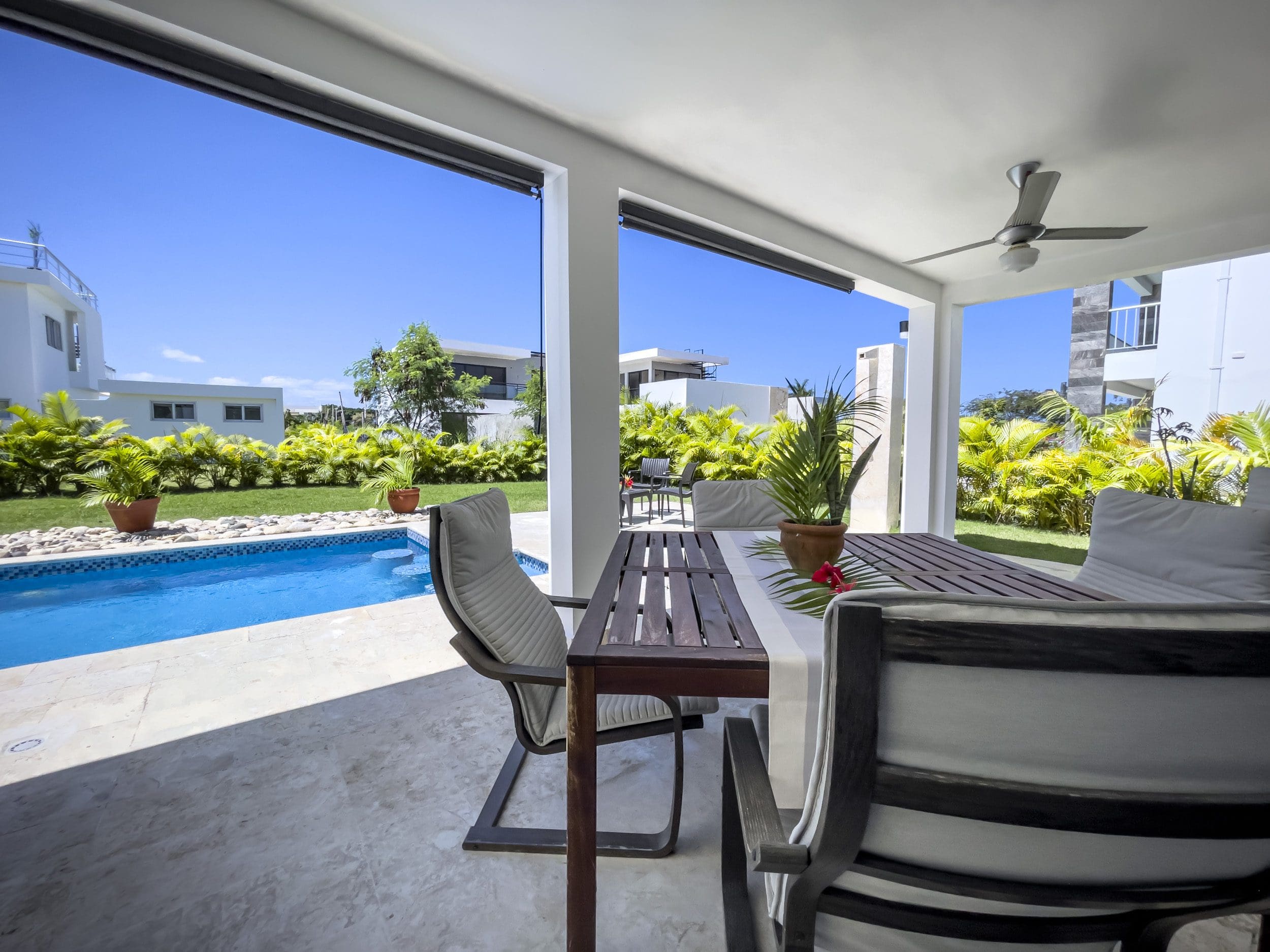 buyDRproperty Outdoor patio of a 2 bedroom villa for sale with a pool and dining table. Sosua Real Estate
