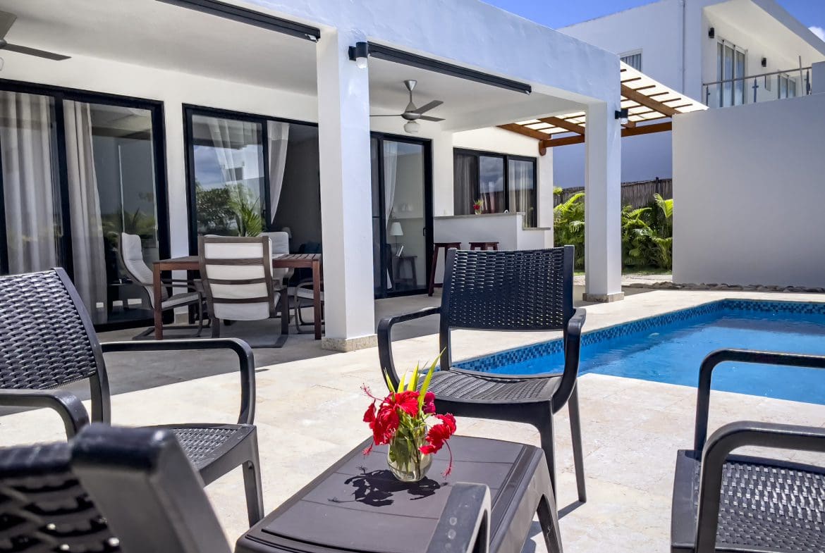 buyDRproperty Exterior view of a 2 bedroom villa for sale with pool and patio furniture. Sosua Real Estate