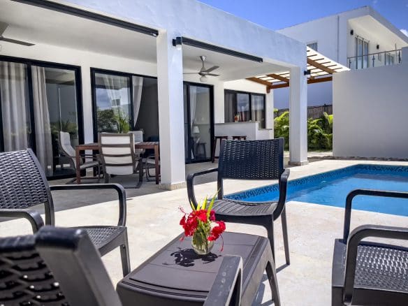 buyDRproperty Exterior view of a 2 bedroom villa for sale with pool and patio furniture. Sosua Real Estate