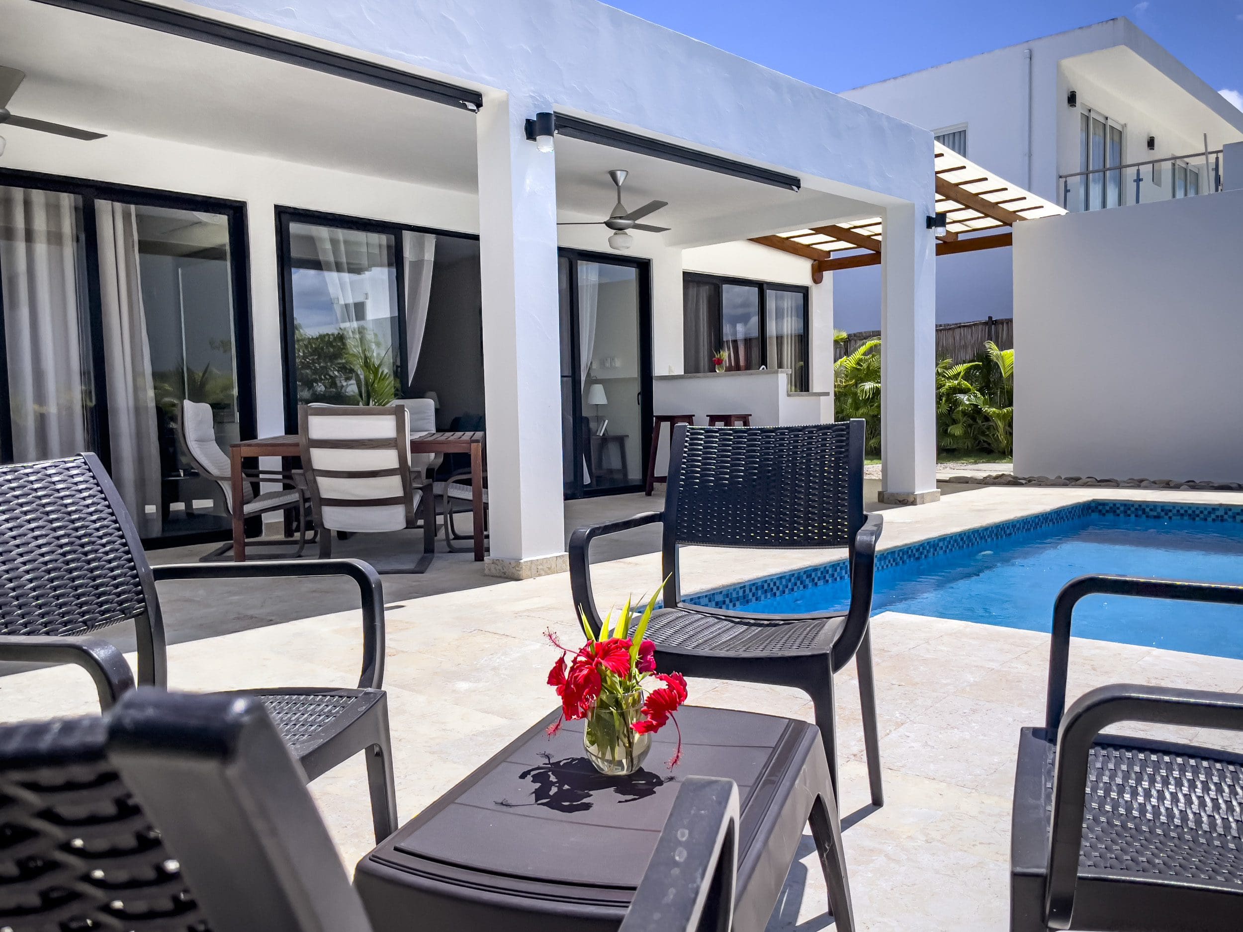 buyDRproperty Exterior view of a 2 bedroom villa for sale with pool and patio furniture. Sosua Real Estate