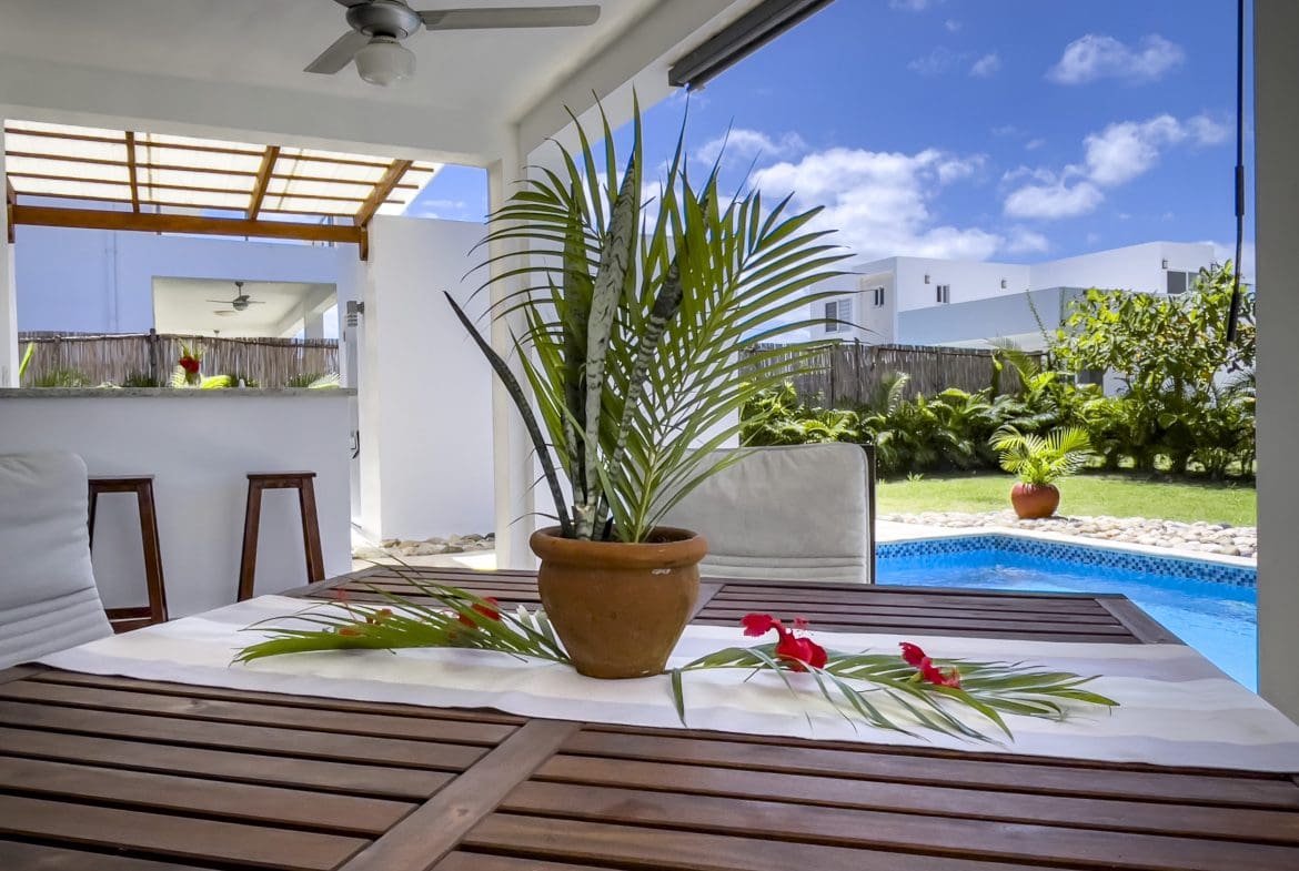 buyDRproperty Outdoor patio with table, potted plant, and 2 Bedroom Villa For Sale in the background Sosua Real Estate
