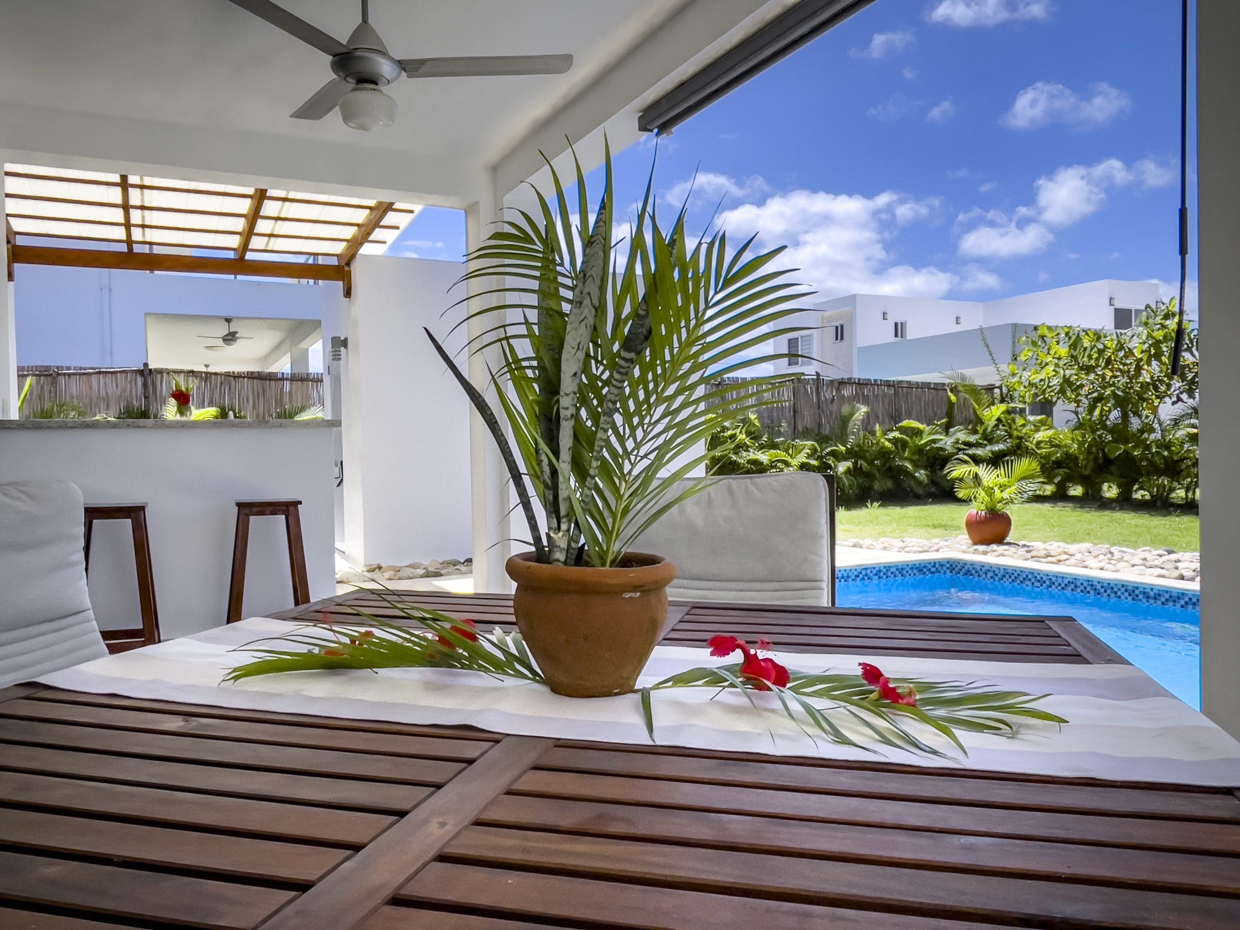 buyDRproperty Outdoor patio with table, potted plant, and 2 Bedroom Villa For Sale in the background Sosua Real Estate