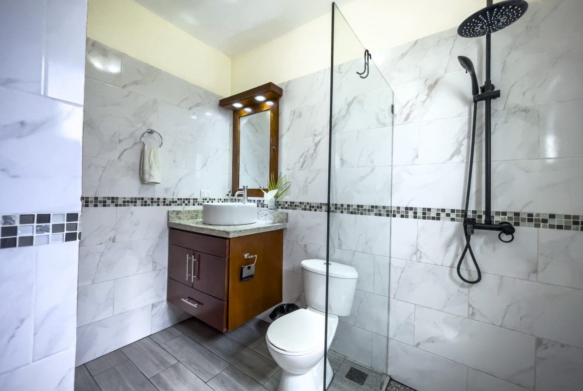 buyDRproperty Modern bathroom with a walk-in shower, toilet, and vanity. 2 Bedroom Villa For Sale. Sosua Real Estate