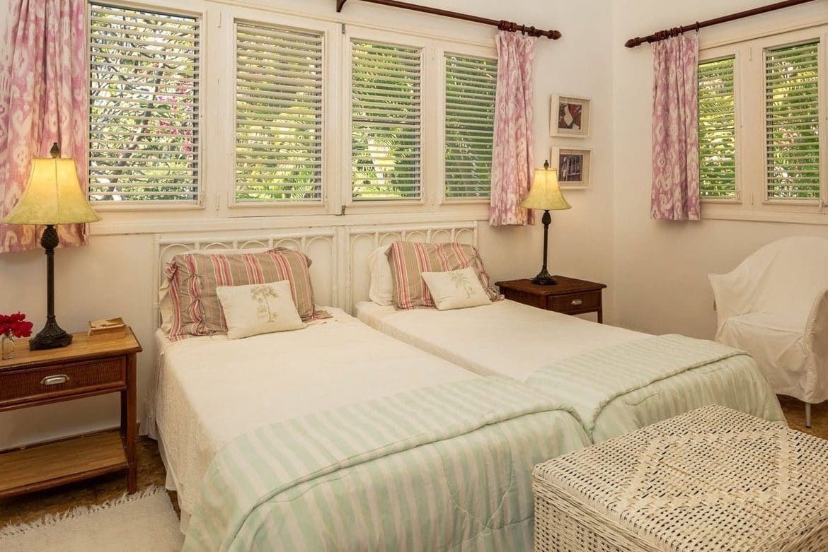 buyDRproperty Bedroom with two twin beds, bedside tables, and window shutters. Sosua Real Estate