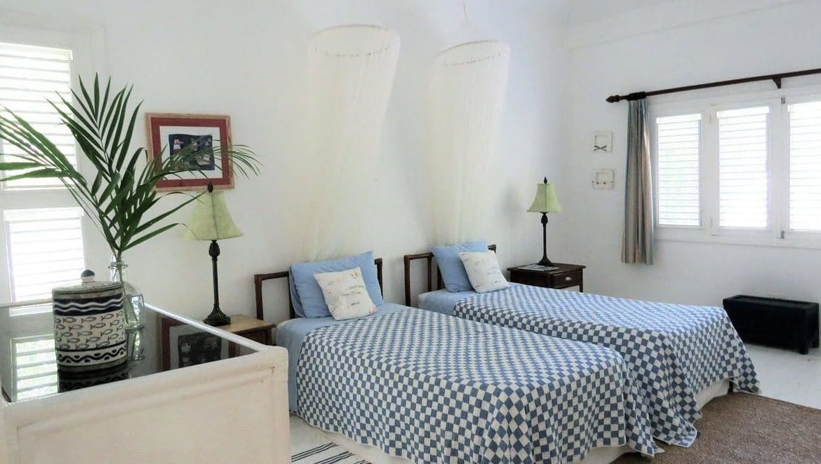 buyDRproperty Twin bedroom at Villa Blanca with blue and white checkered bedding and mosquito nets. Sosua Real Estate