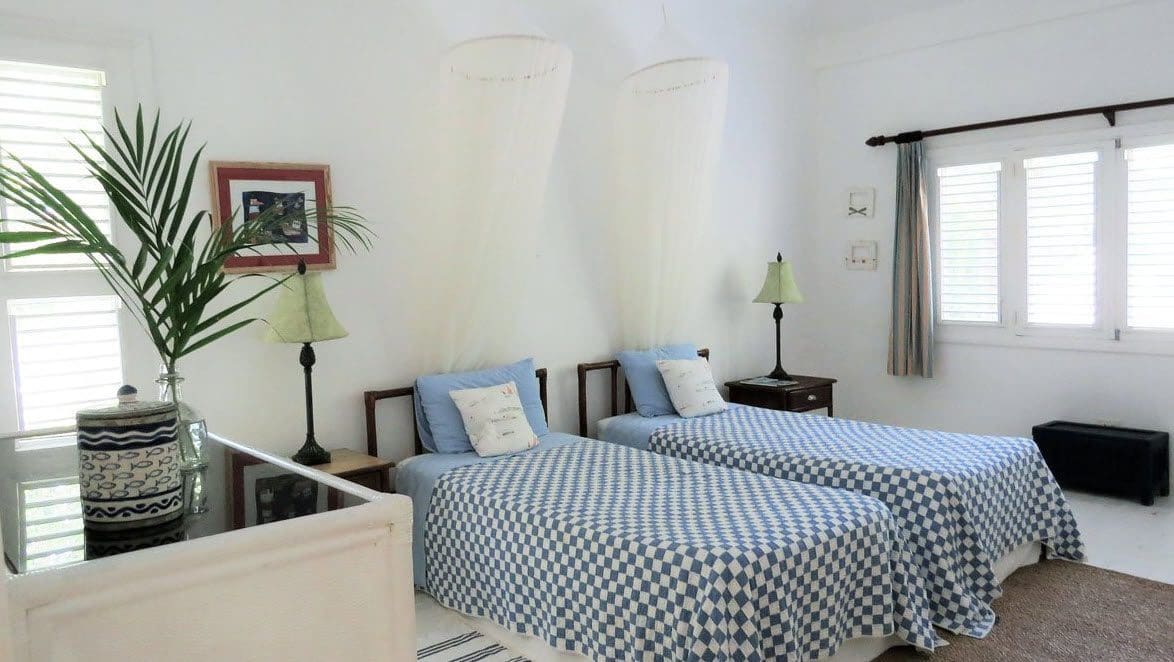 buyDRproperty Twin bedroom at Villa Blanca with blue and white checkered bedding and mosquito nets. Sosua Real Estate