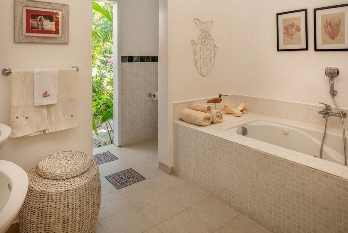 buyDRproperty Villa Blanca bathroom with bathtub, towels, and decorative accents. Sosua Real Estate