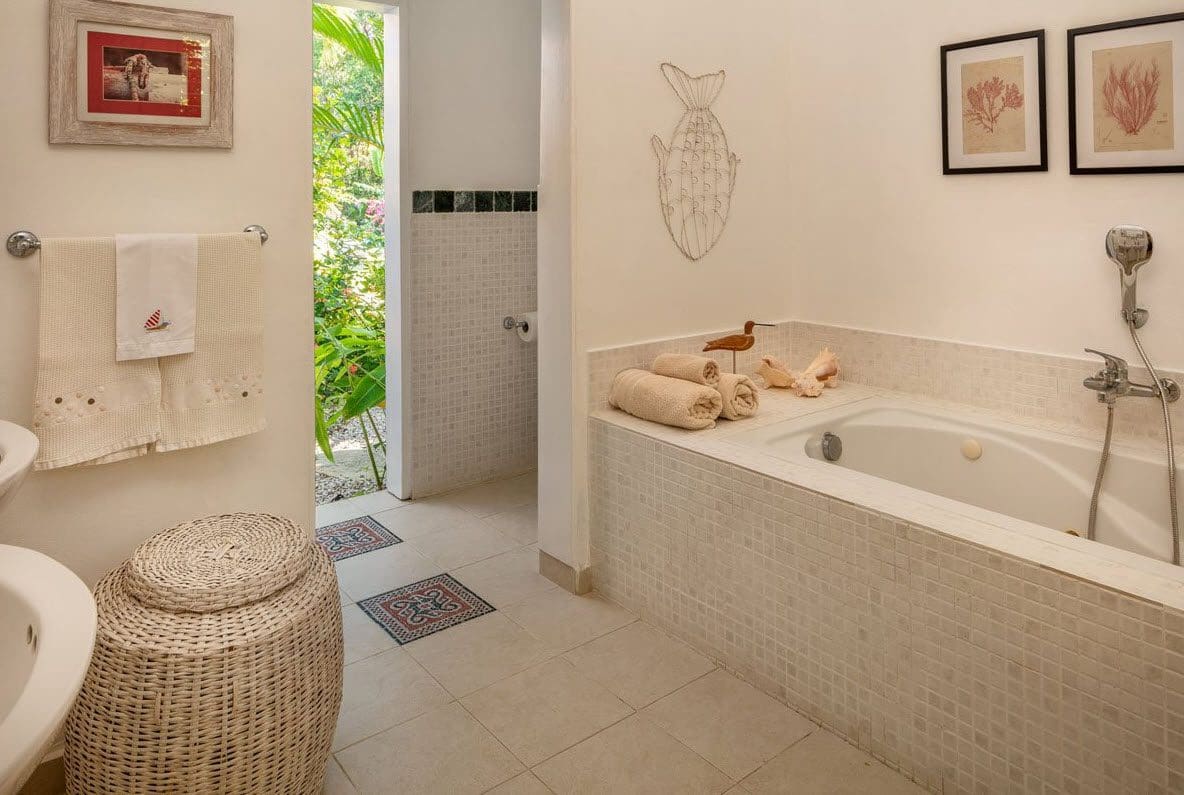 buyDRproperty Villa Blanca bathroom with bathtub, towels, and decorative accents. Sosua Real Estate