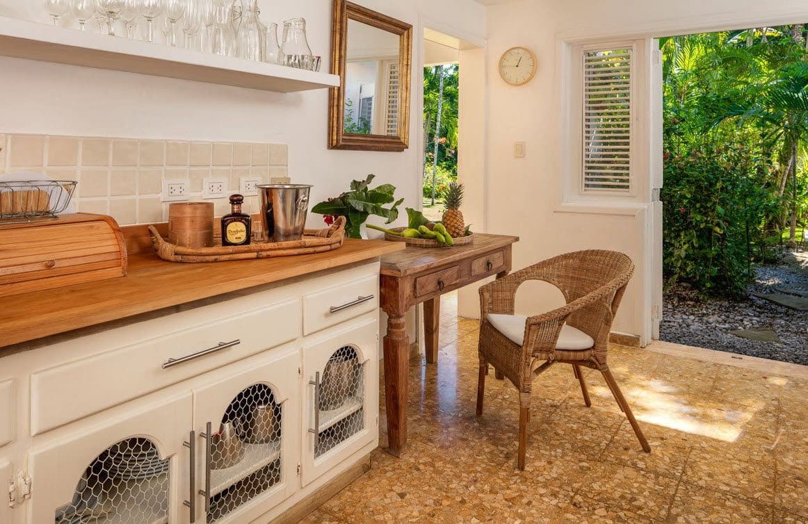 buyDRproperty Kitchen area in Villa Blanca with wooden countertops, wire mesh cabinets, and a view to the lush garden. Sosua Real Estate