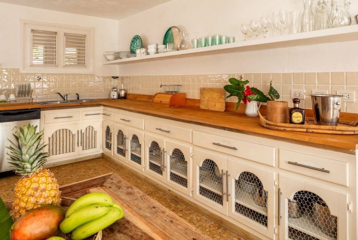buyDRproperty Kitchen in Villa Blanca with wooden countertops and chicken wire cabinet doors. Sosua Real Estate