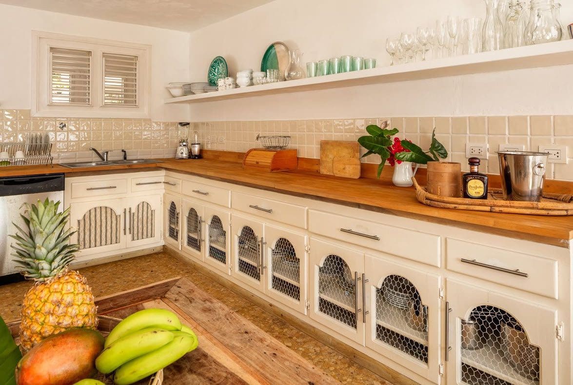 buyDRproperty Kitchen in Villa Blanca with wooden countertops and chicken wire cabinet doors. Sosua Real Estate