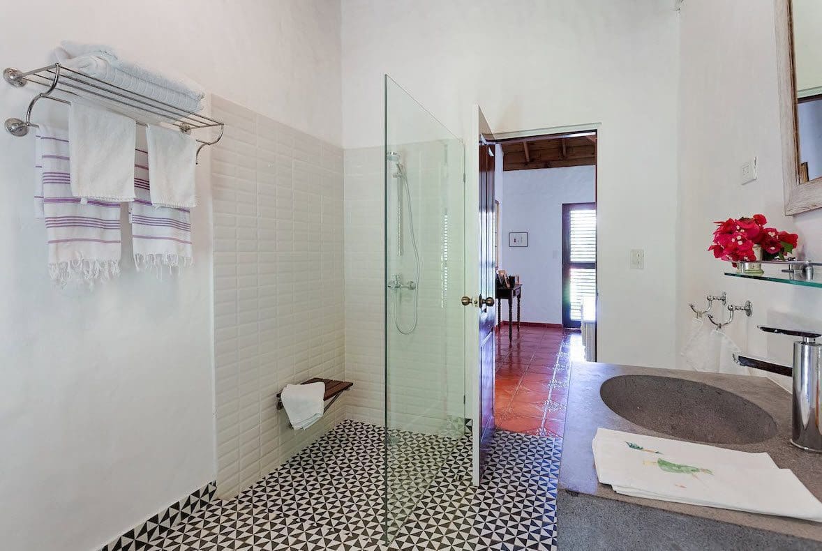buyDRproperty Bathroom with white tiled walls and black and white patterned floor in a Sea Horse Ranch Villa. Sosua Real Estate