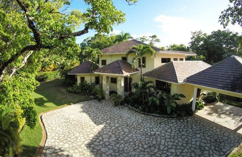 buyDRproperty Beautiful VILLA BRILLANTE exterior with stone driveway and lush landscaping. Sosua Real Estate