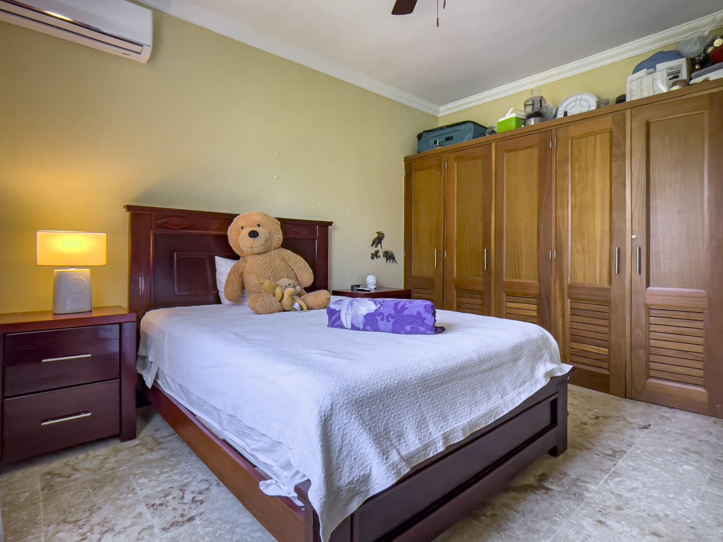 buyDRproperty Cozy bedroom with a large teddy bear on the bed Sosua Real Estate
