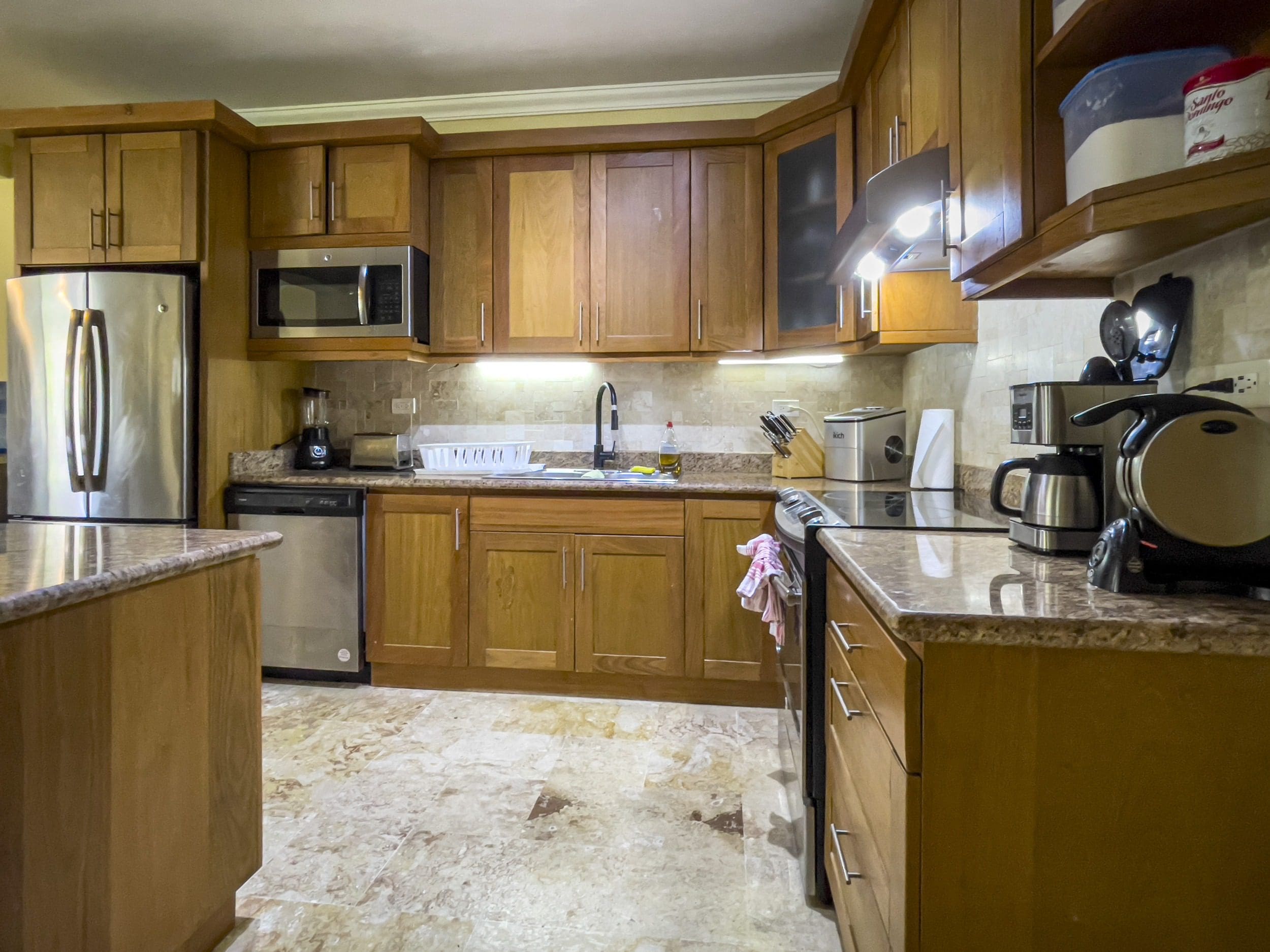 buyDRproperty Kitchen with wooden cabinets, stainless steel appliances, and granite countertop. Sosua Real Estate