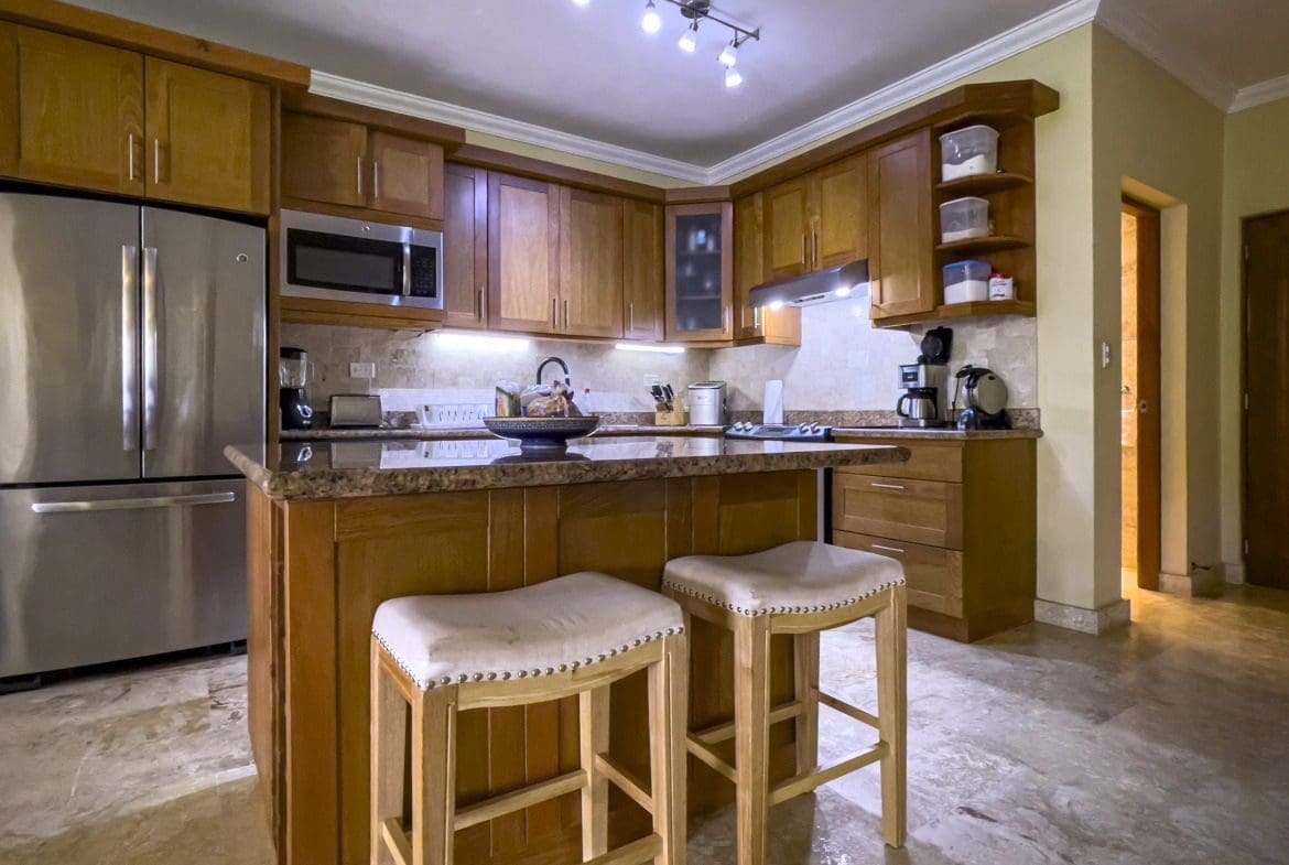 buyDRproperty Wooden kitchen island with stools in a condo for sale in Sosua Sosua Real Estate