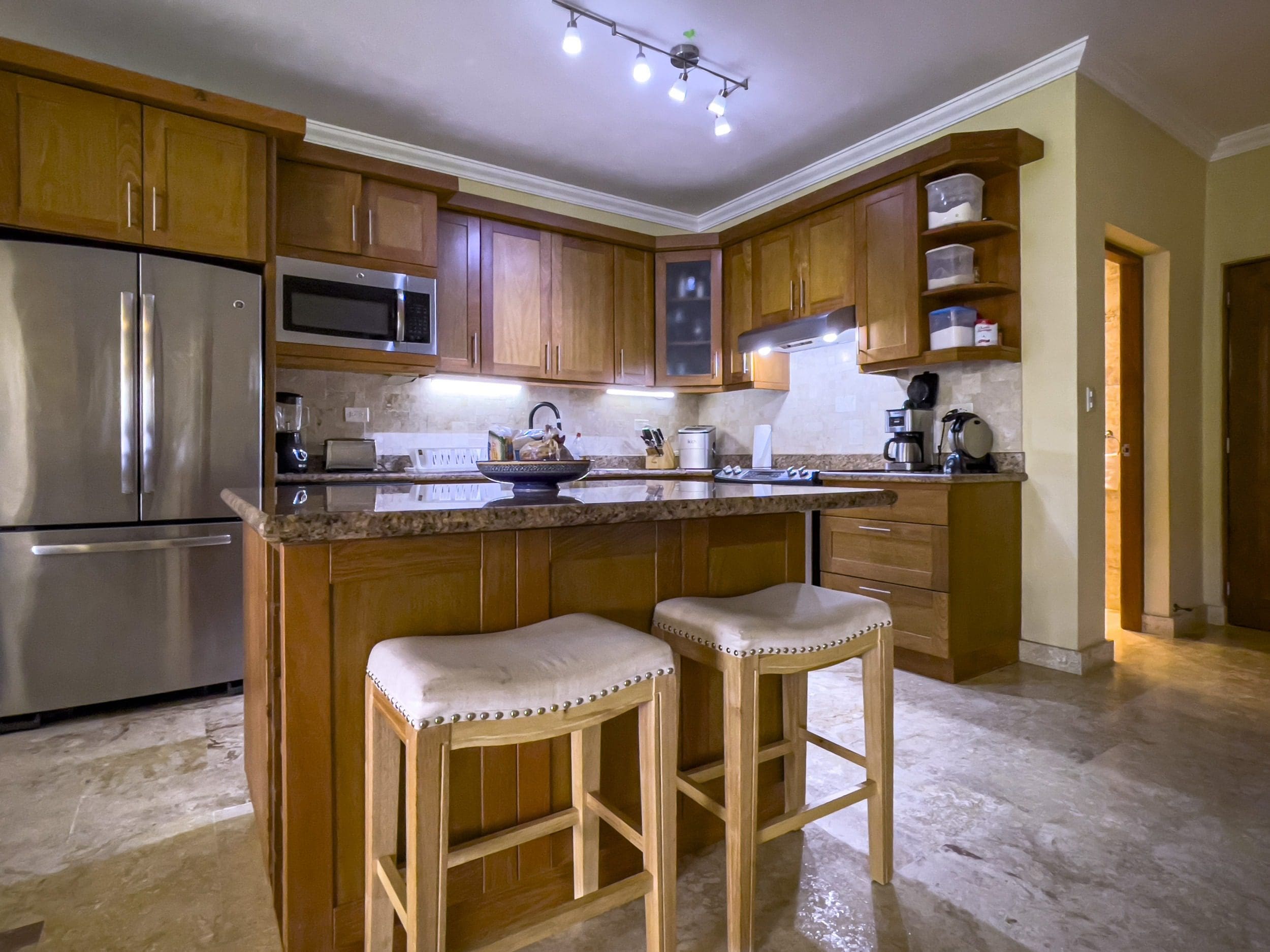 buyDRproperty Wooden kitchen island with stools in a condo for sale in Sosua Sosua Real Estate