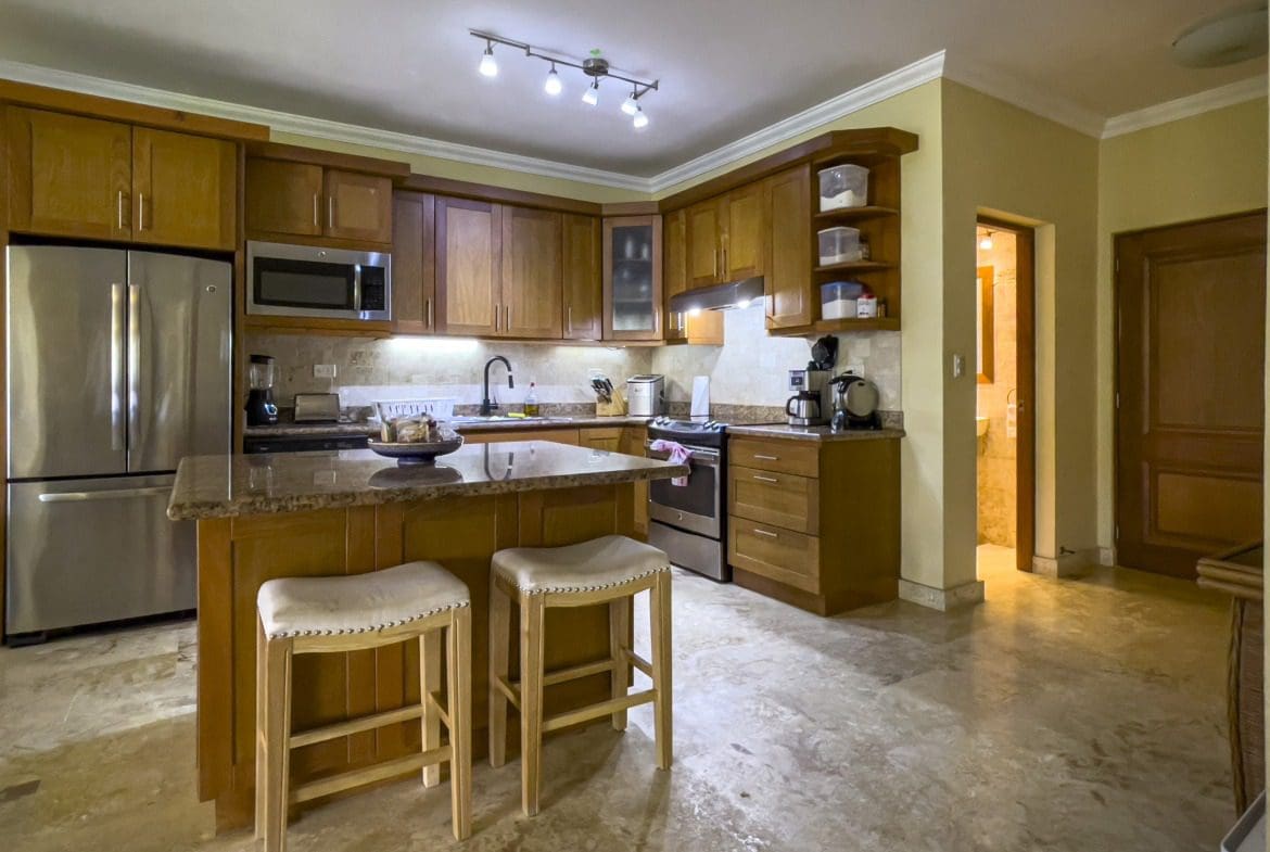 buyDRproperty Spacious kitchen with wooden cabinets and granite countertops in a Sosua condo. Sosua Real Estate