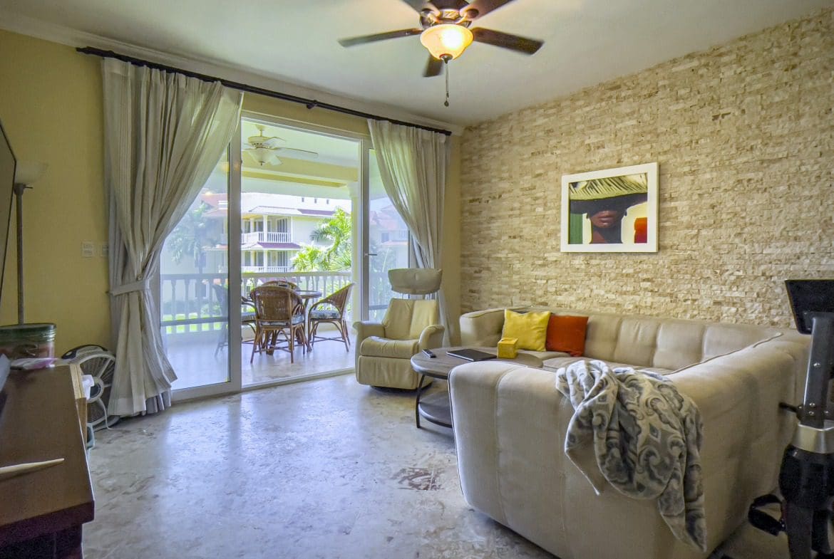 buyDRproperty Living room in a Sosua oceanfront condo with sofa and balcony access. Sosua Real Estate