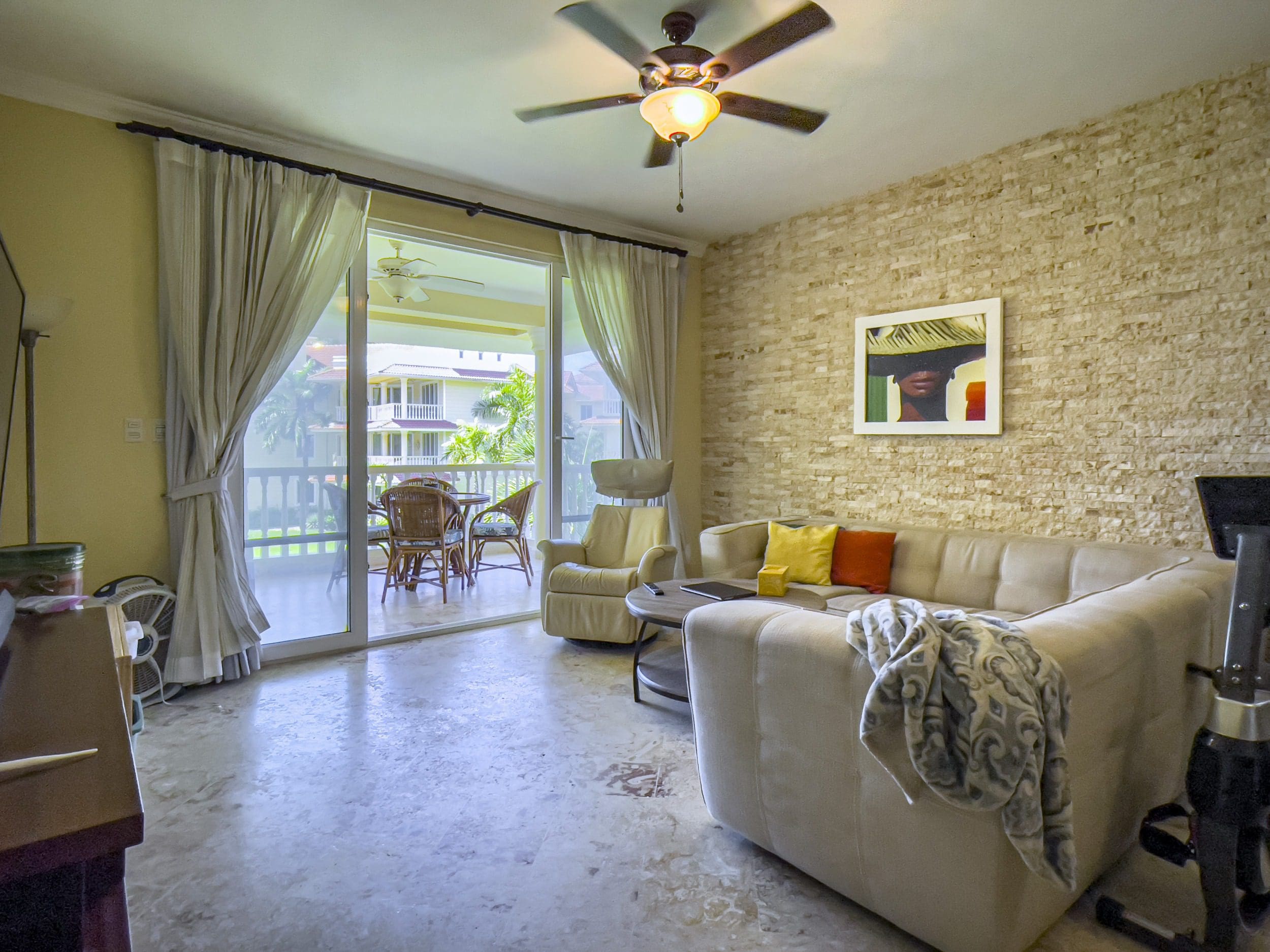 buyDRproperty Living room in a Sosua oceanfront condo with sofa and balcony access. Sosua Real Estate