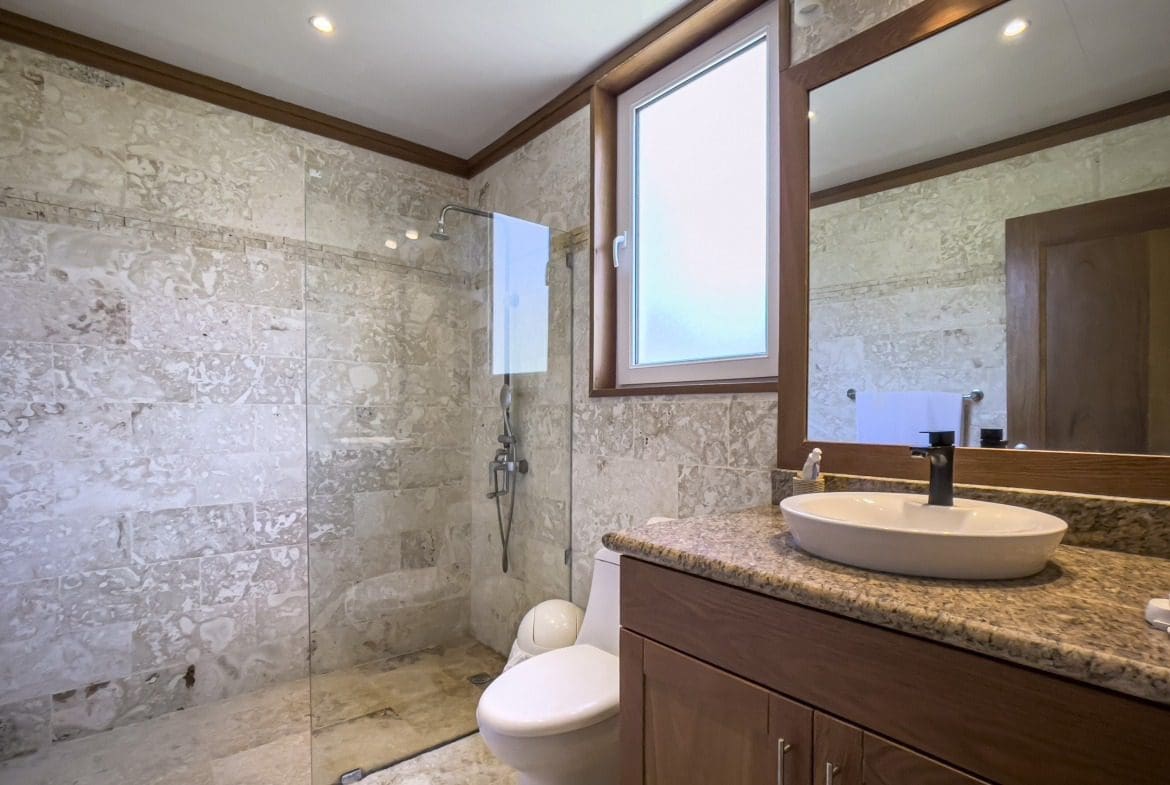 buyDRproperty Luxurious bathroom with marble tile shower and wooden vanity Sosua Real Estate