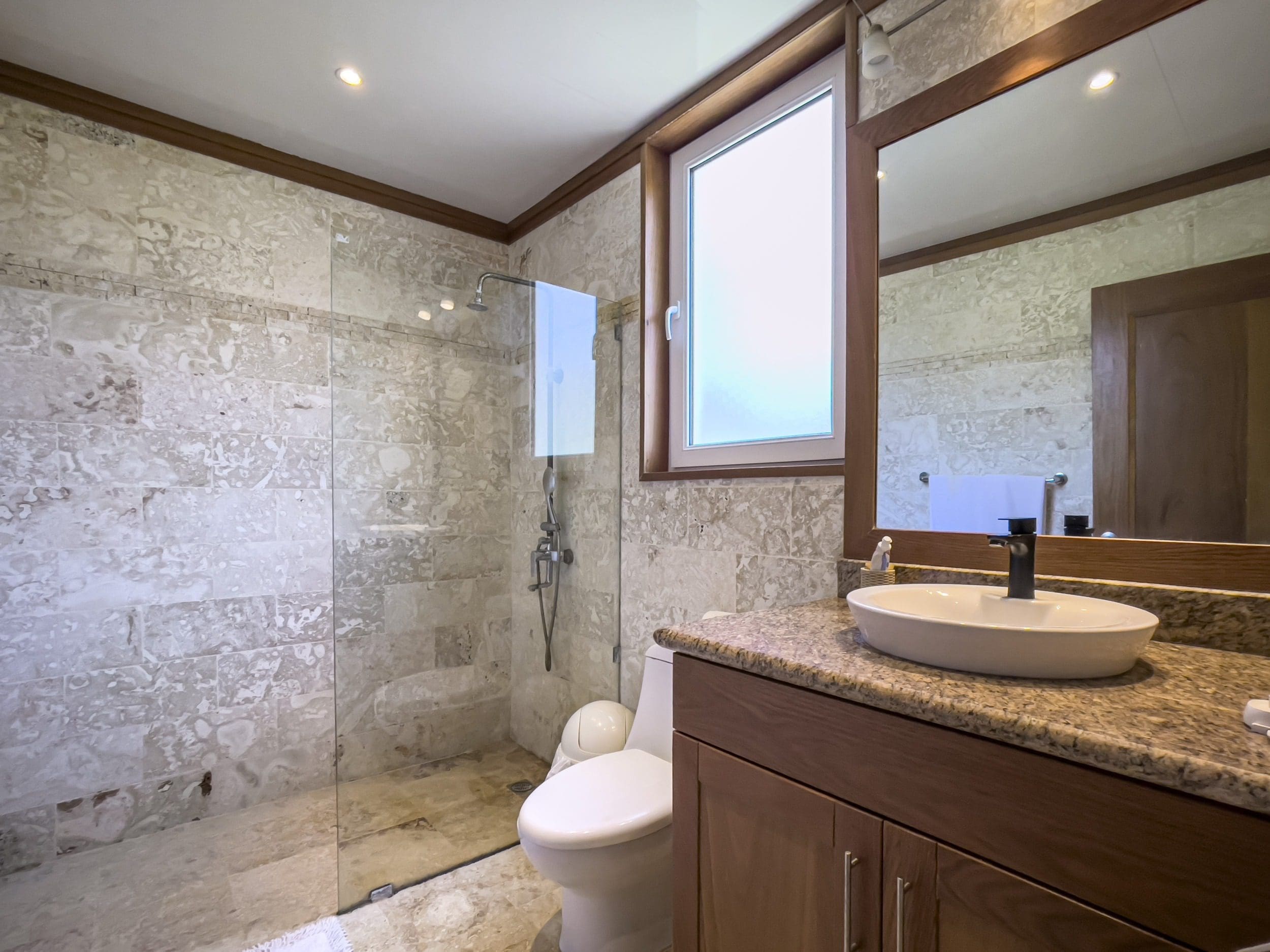 buyDRproperty Luxurious bathroom with marble tile shower and wooden vanity Sosua Real Estate