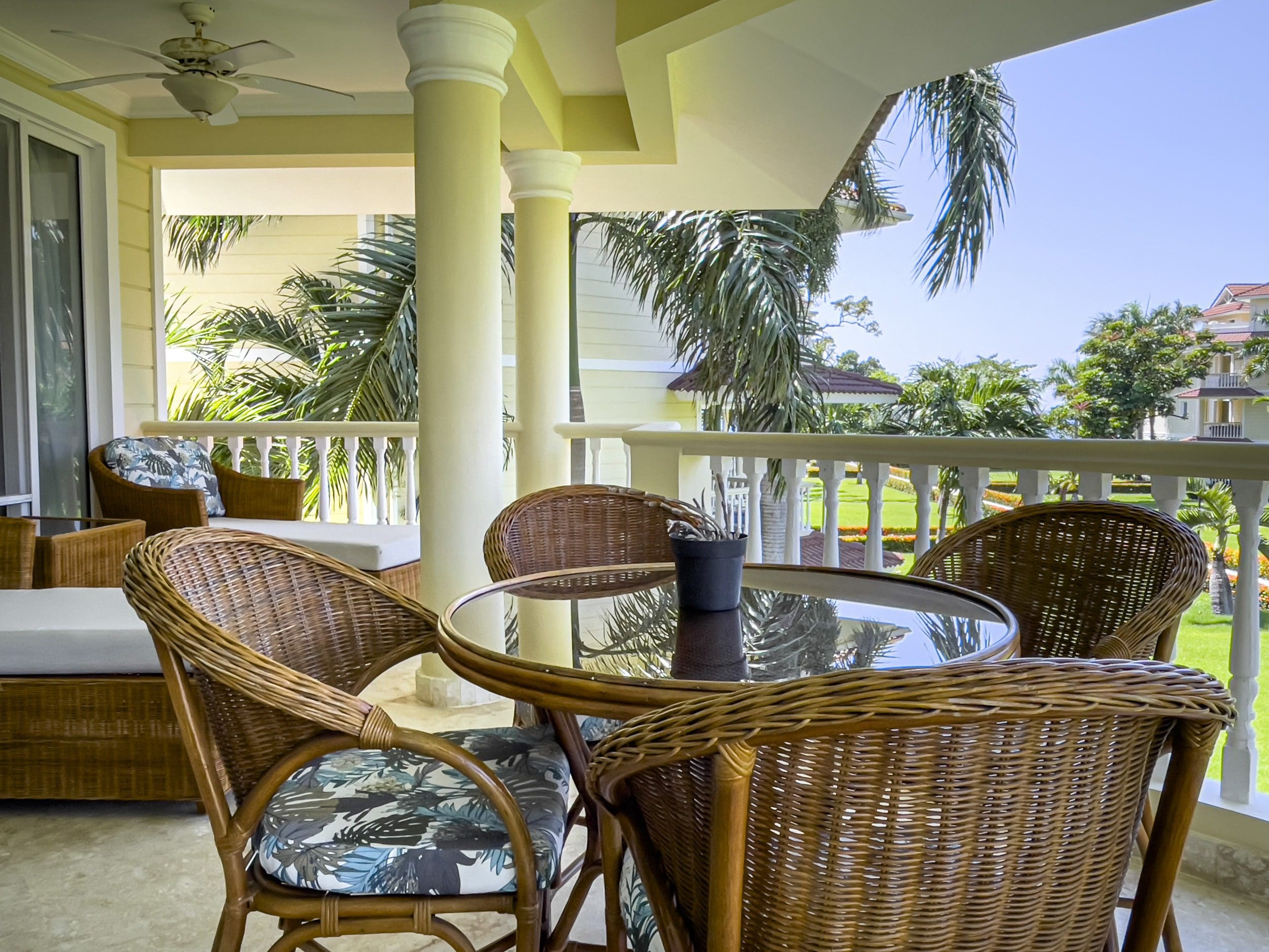 buyDRproperty Wicker patio furniture on a balcony overlooking a tropical view from an oceanfront condo in Sosua. Sosua Real Estate