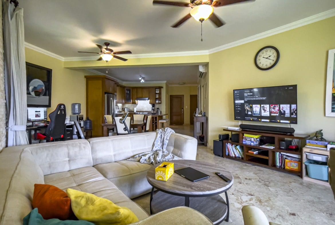 buyDRproperty Living room in a Sosua condo with a comfortable sofa and TV. Sosua Real Estate