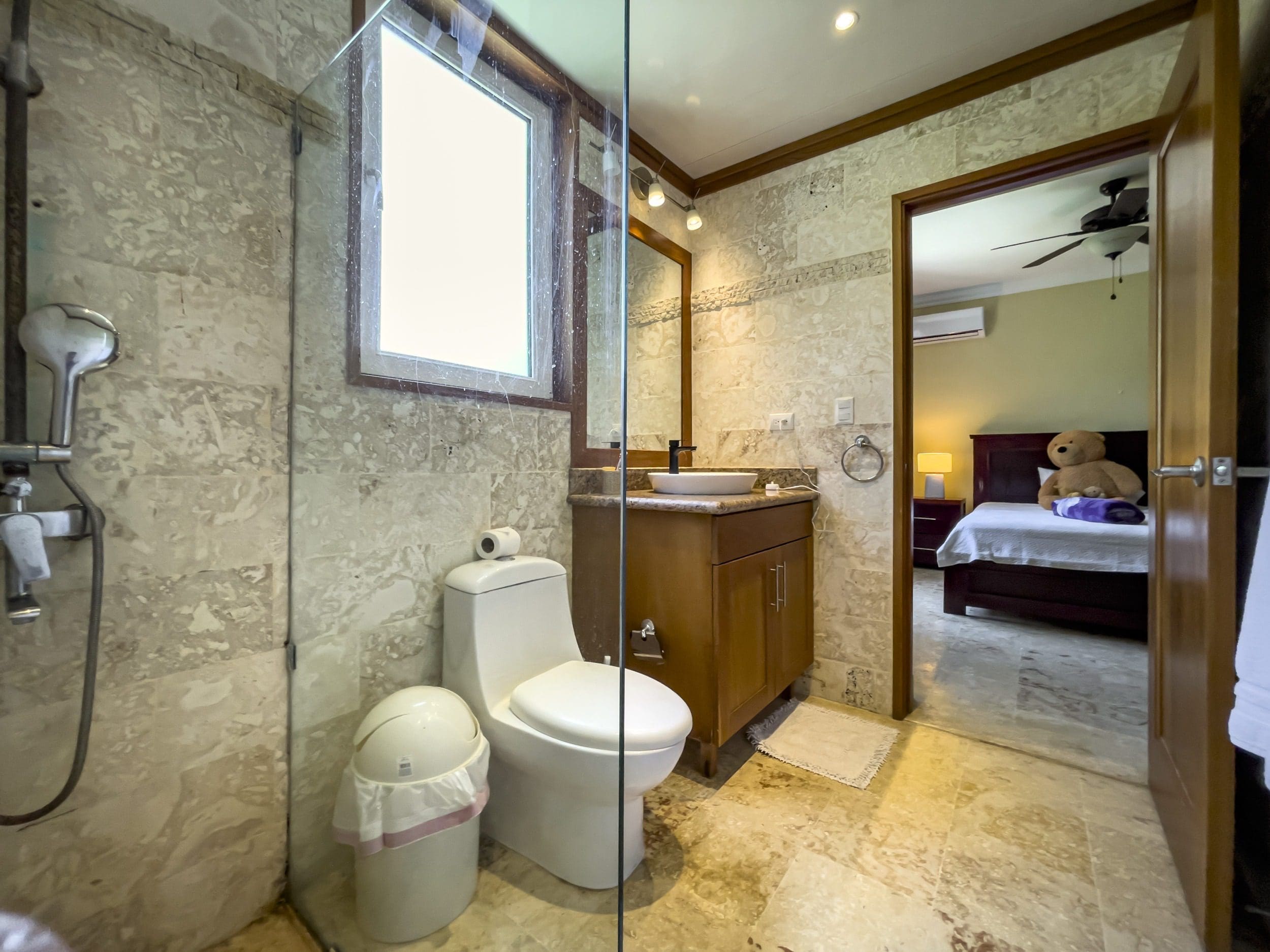 buyDRproperty Bathroom with shower, toilet, and vanity in a Sosua condo. Sosua Real Estate