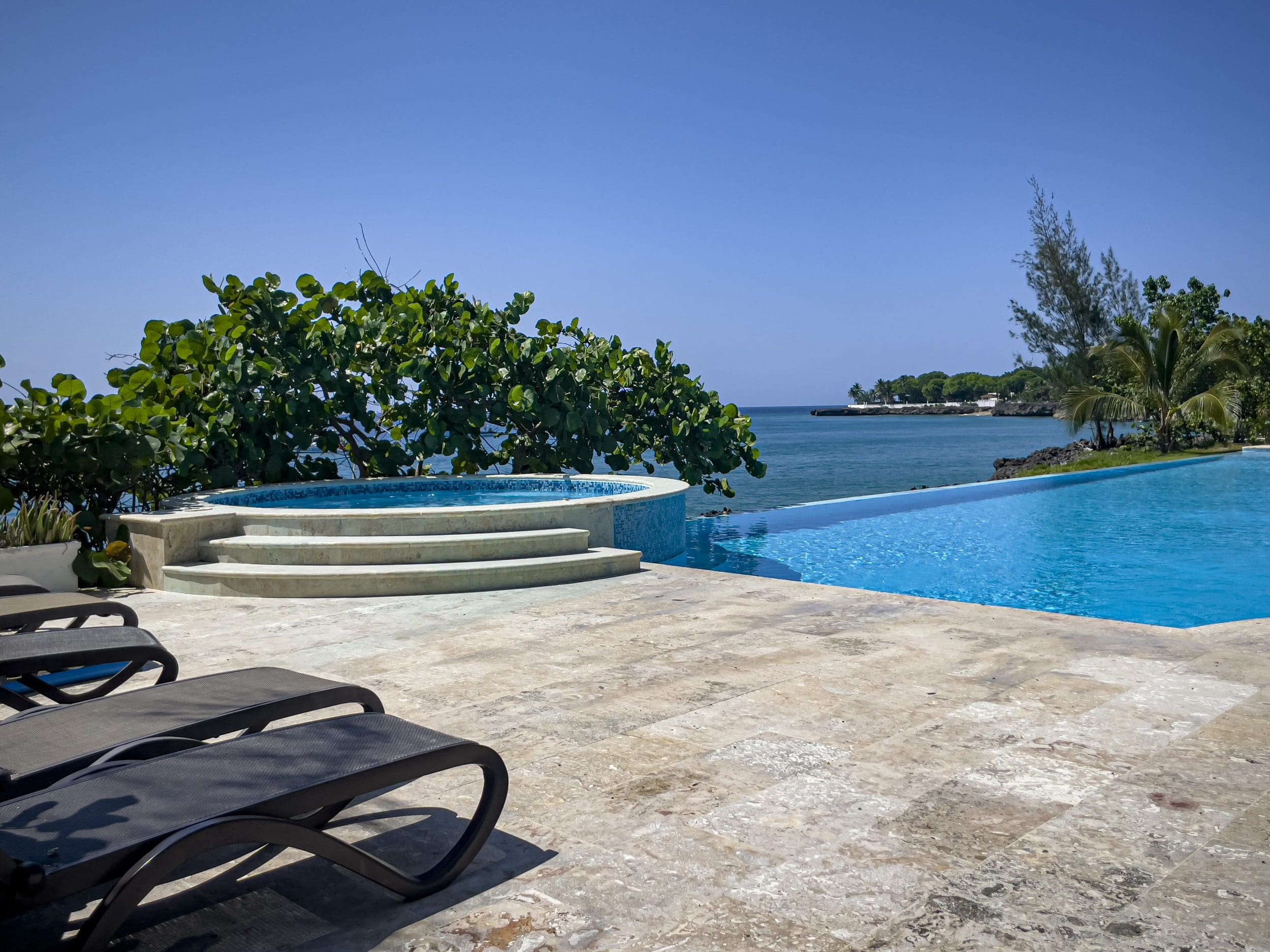 buyDRproperty Luxury oceanfront pool and jacuzzi overlooking the ocean on a sunny day. Sosua Real Estate