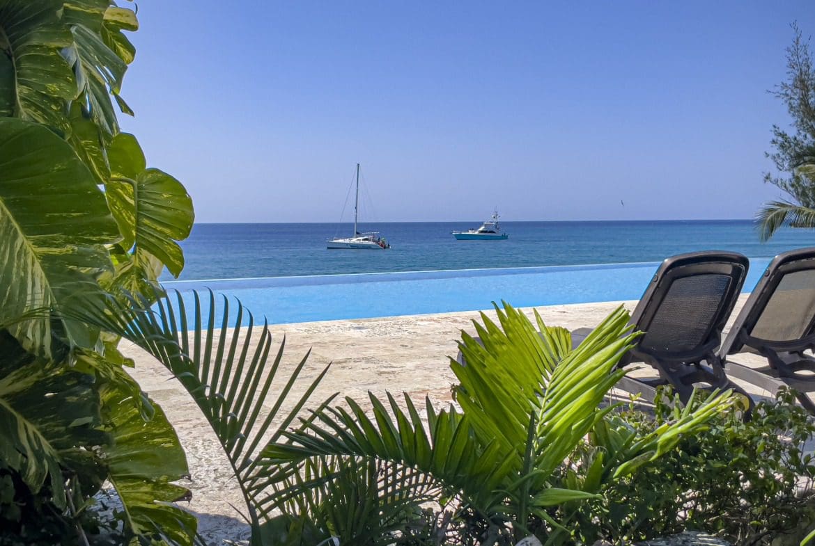 buyDRproperty Ocean view from infinity pool at a Sosua condo with boats on the horizon. Sosua Real Estate