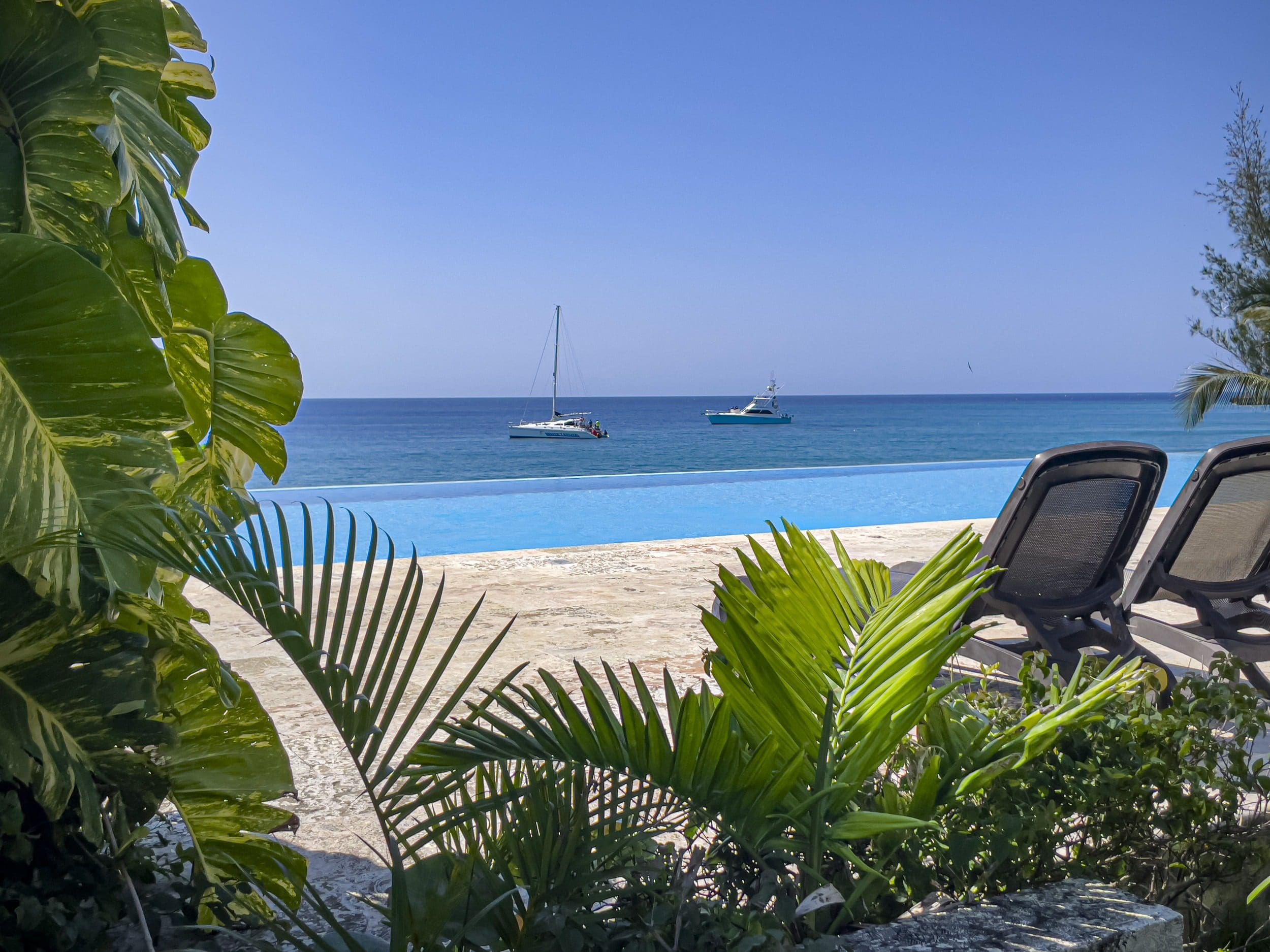 buyDRproperty Ocean view from infinity pool at a Sosua condo with boats on the horizon. Sosua Real Estate